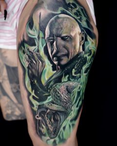 Tätowierung, die Lord Voldemort umgeben von grünem Rauch darstellt, unter ihm seine Schlange Nagini