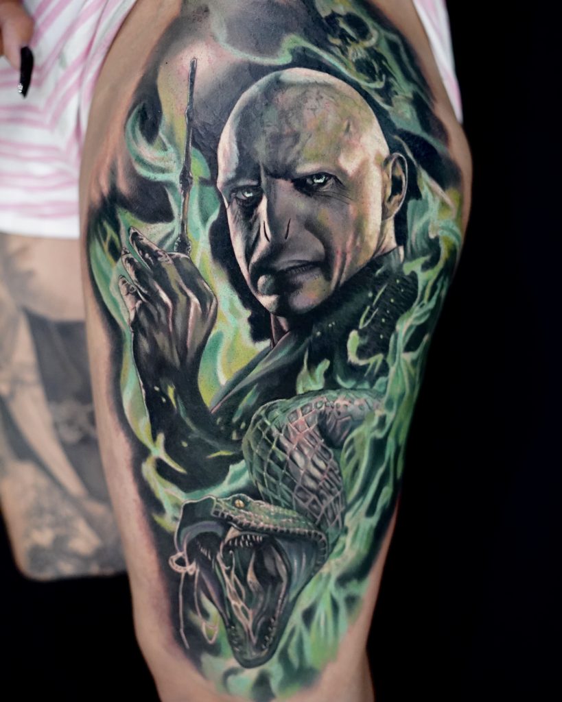 Realistic Voldemort Tattoo am Oberschenkel mit Schlange und magischem grünen Effekt – Harry Potter Motiv von Skyline Tattoo in Bayern