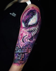 Rosa Tattoo, das ein Monster mit scharfen Zähnen darstellt.