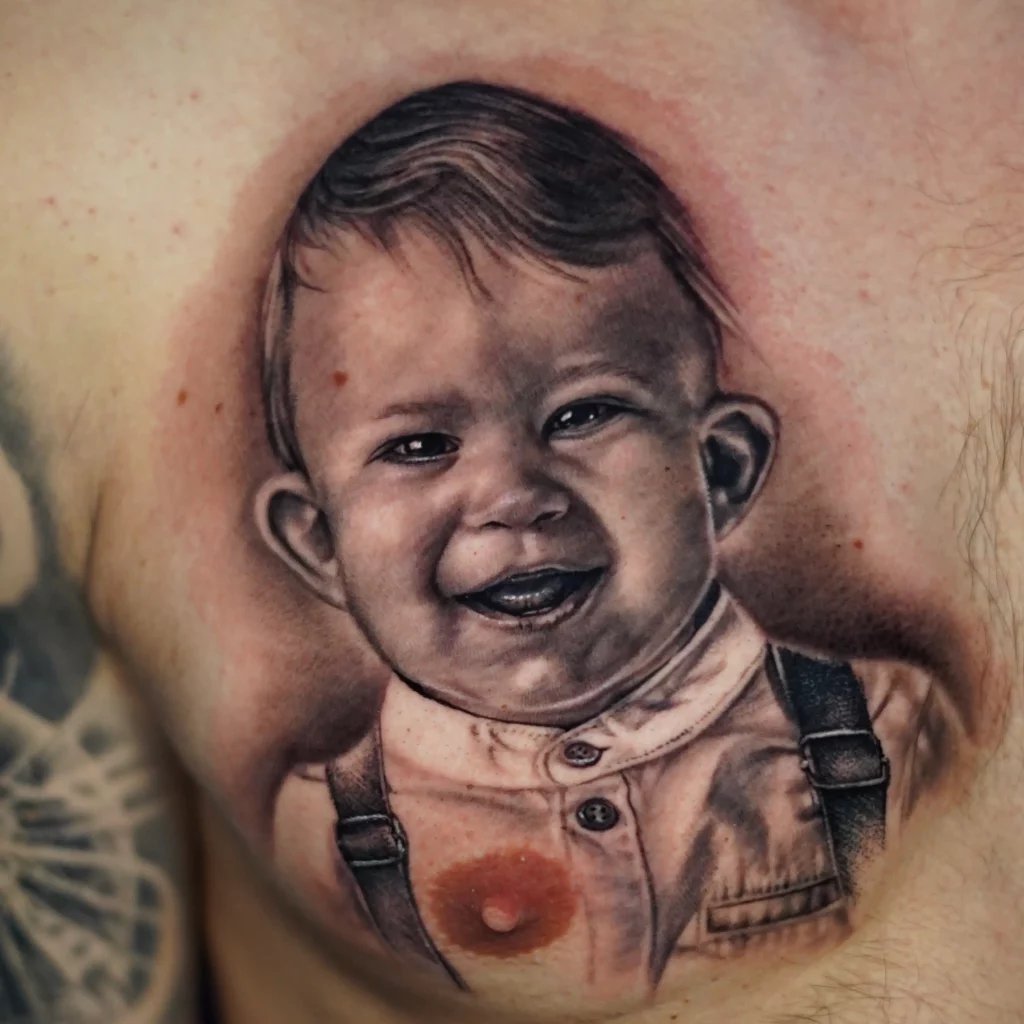 Realistisches Brust Tattoo eines Baby Portraits in Black and Grey - gestochen bei Skyline Tattoo