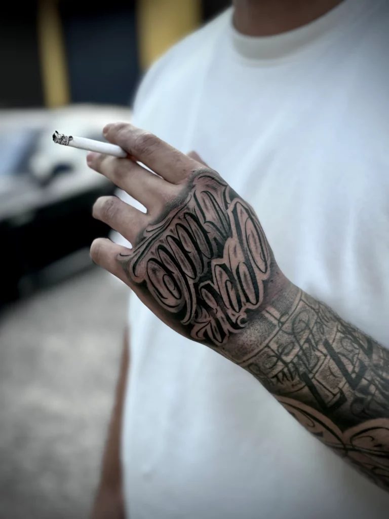 Detailaufnahme eines modernen Hand Tattoos mit ausdrucksstarkem Schriftzug im Realistic Lettering Stil, individuell für den Kunden entworfen und mit hoher Präzision und Tiefe gestochen bei Skyline Tattoo