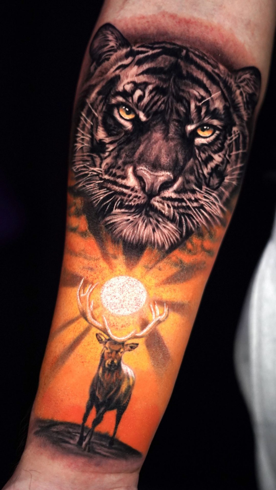 Tätowierung, die einen Tiger mit einer Sonne und einem Hirsch darunter darstellt.